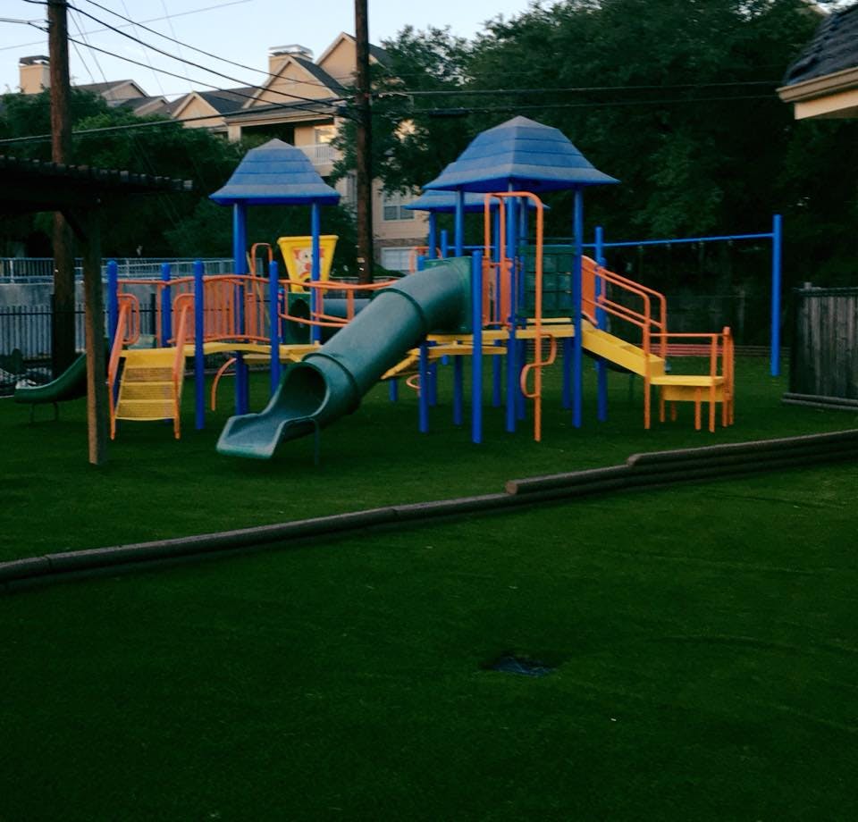 Playground with slides and climbing structures on green turf