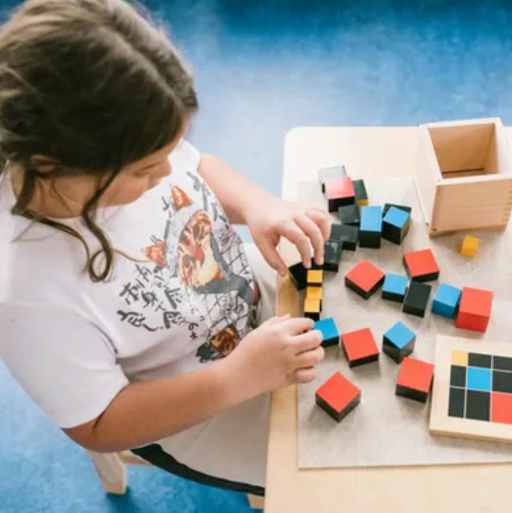Child playing with colorful blocks at a table