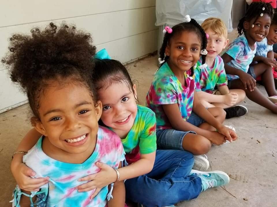 Group of children sitting together, smiling at the camera