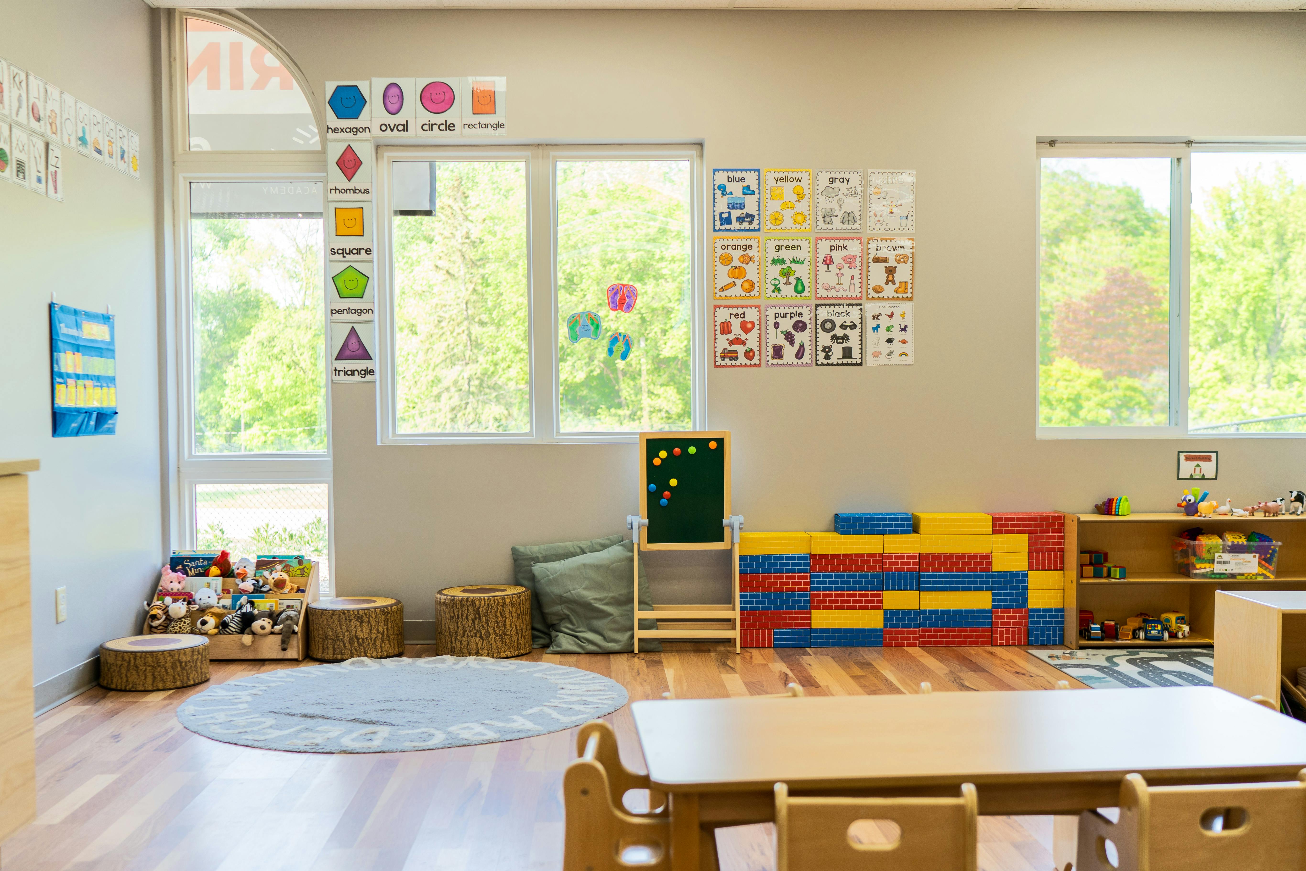 Empty classroom with small tables, chairs, and colorful learning materials