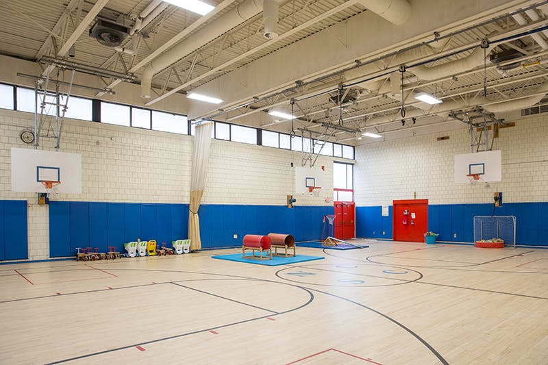Empty school gymnasium with basketball hoops and gym equipment