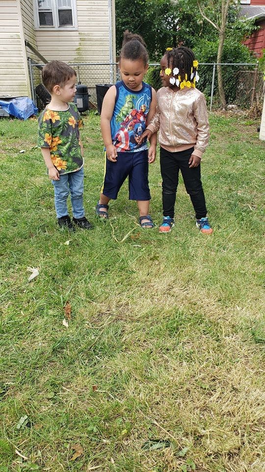 Three children standing on grass
