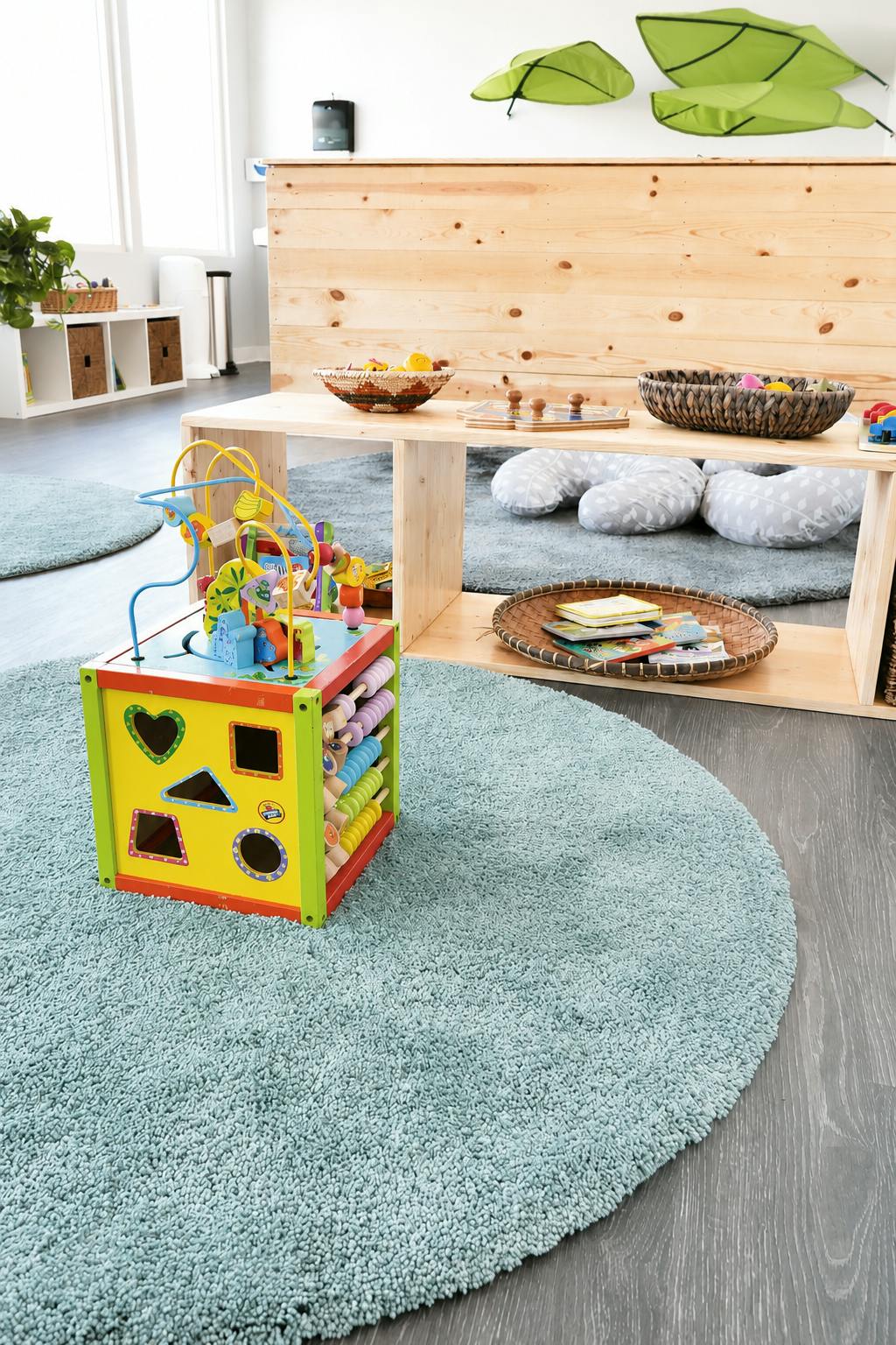 Wooden activity cube on a round rug in a children's play area
