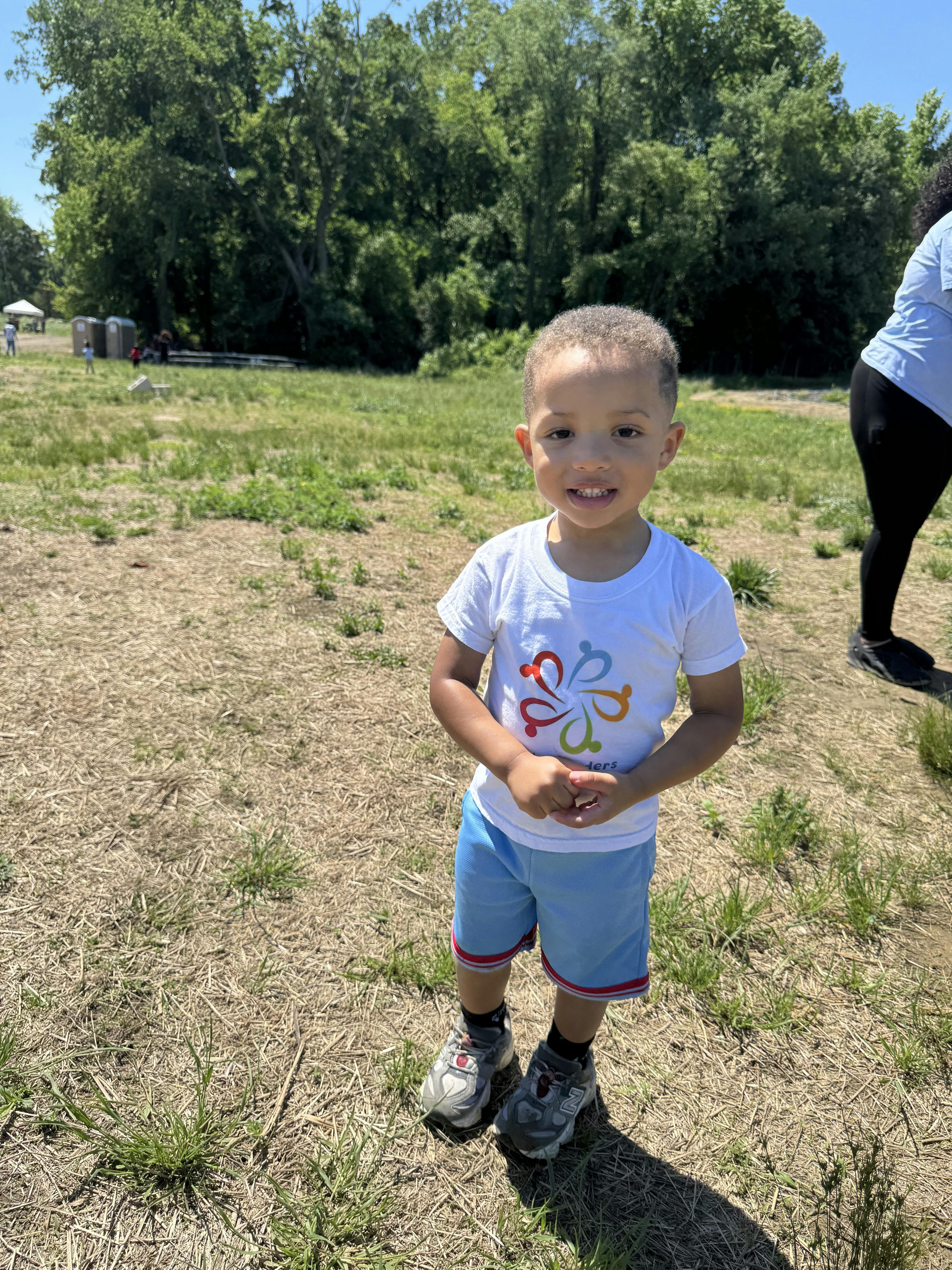 A young child standing in a grassy field