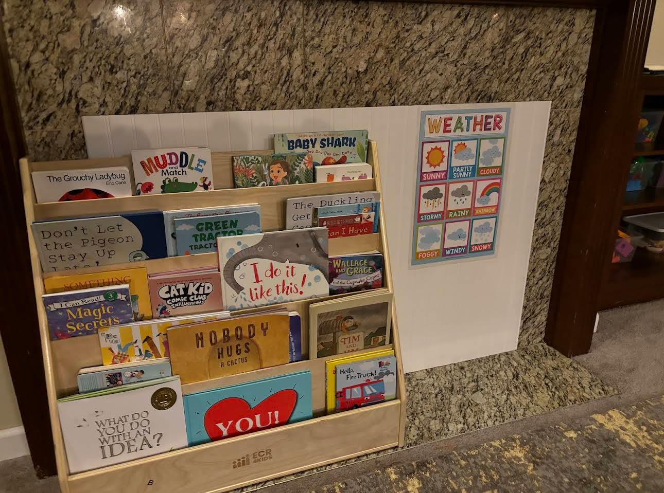 Children's book display shelf next to a weather chart