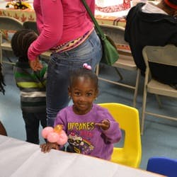Child in purple shirt sitting at a table