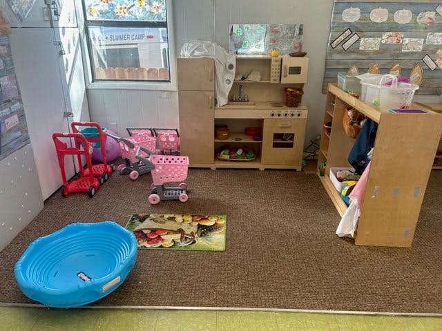 Playroom with toy kitchen, shopping carts, and blue basin