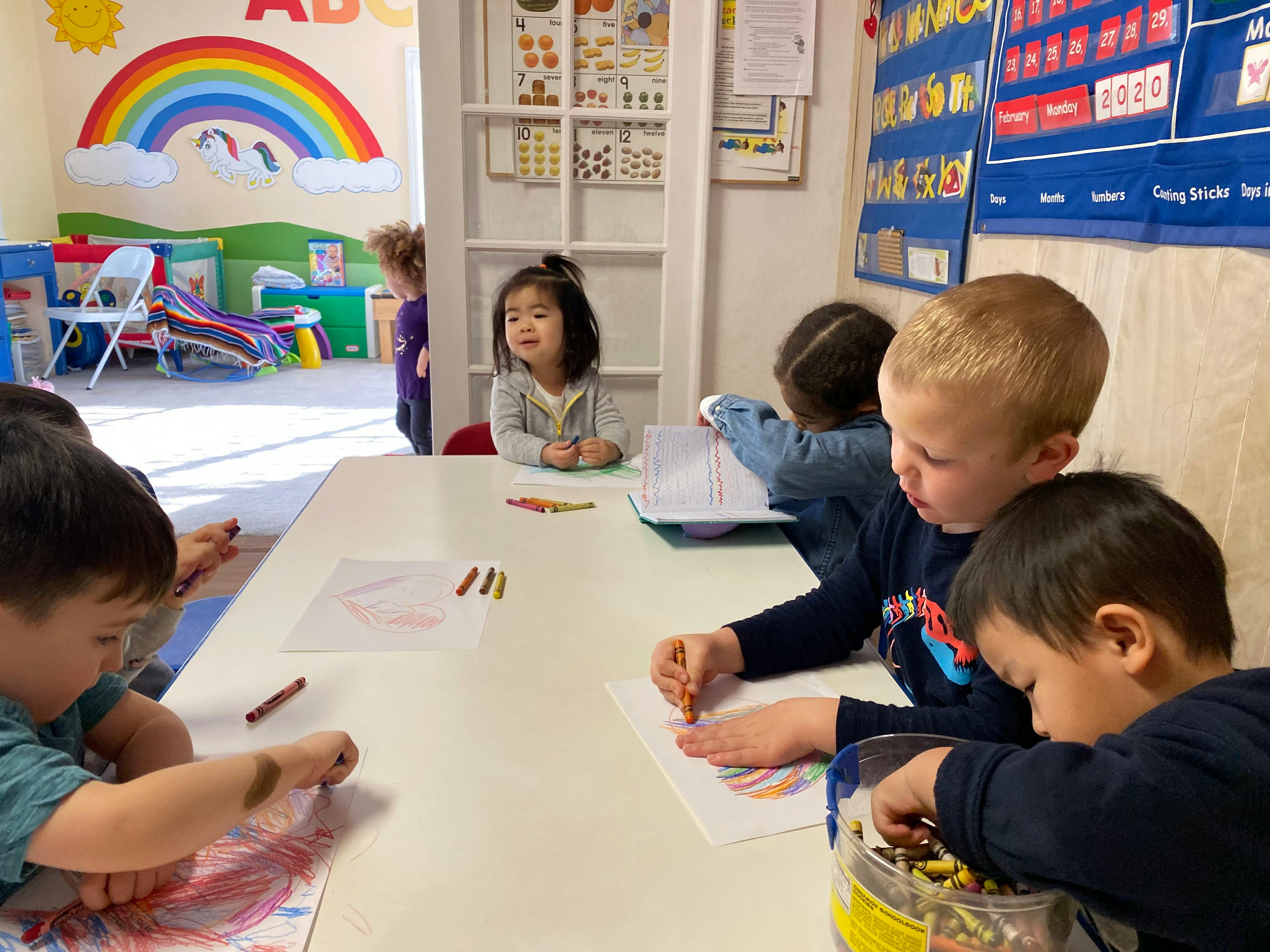 Children drawing at a table in a classroom