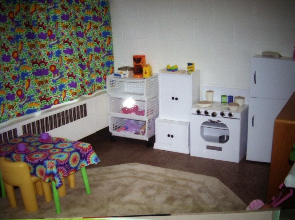 Play kitchen set with toy stove, refrigerator, and storage shelves