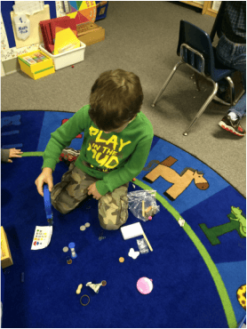 Child playing with small objects on a blue rug