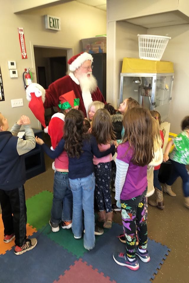 Person dressed as Santa Claus with a group of children