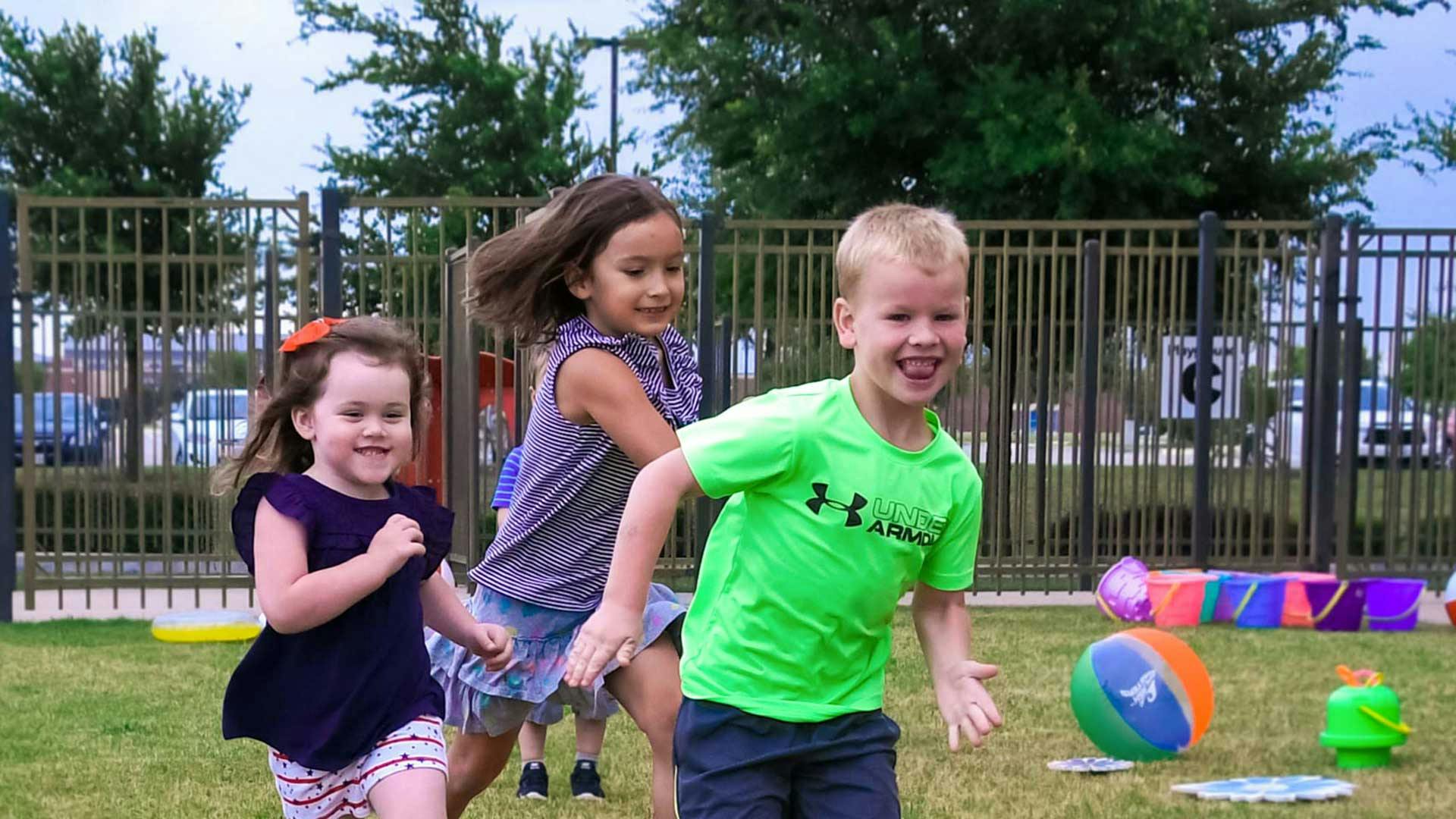 Three children running and playing outdoors