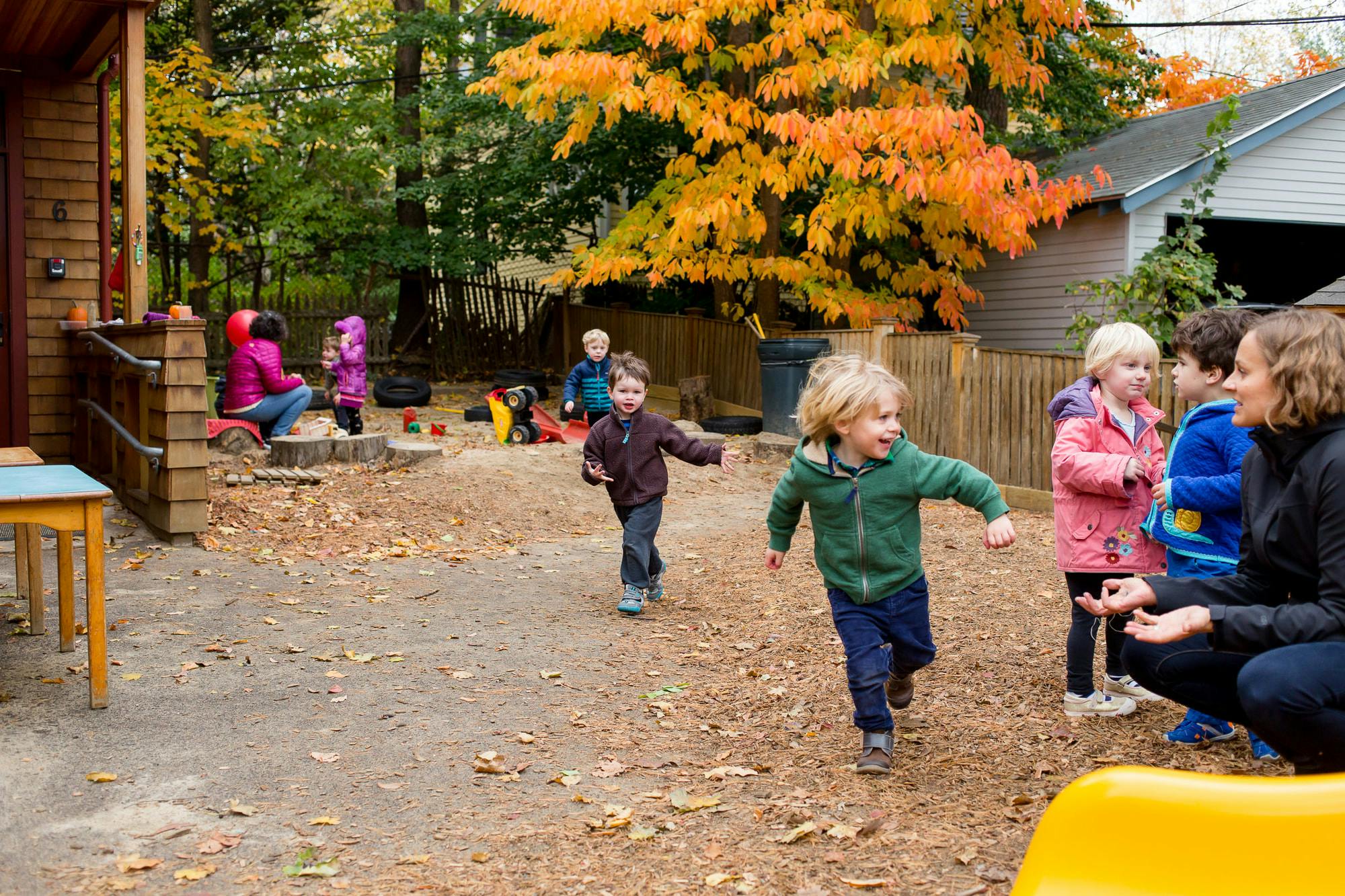 Children playing outdoors with an adult