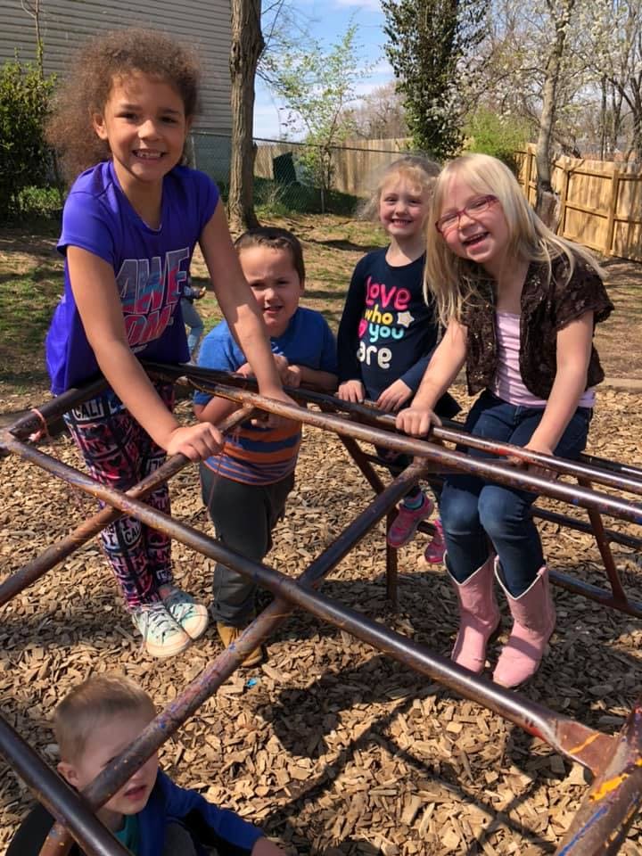 Children playing on a metal climbing structure outdoors