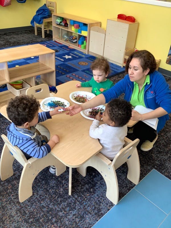 Adult and three children at a table with craft supplies