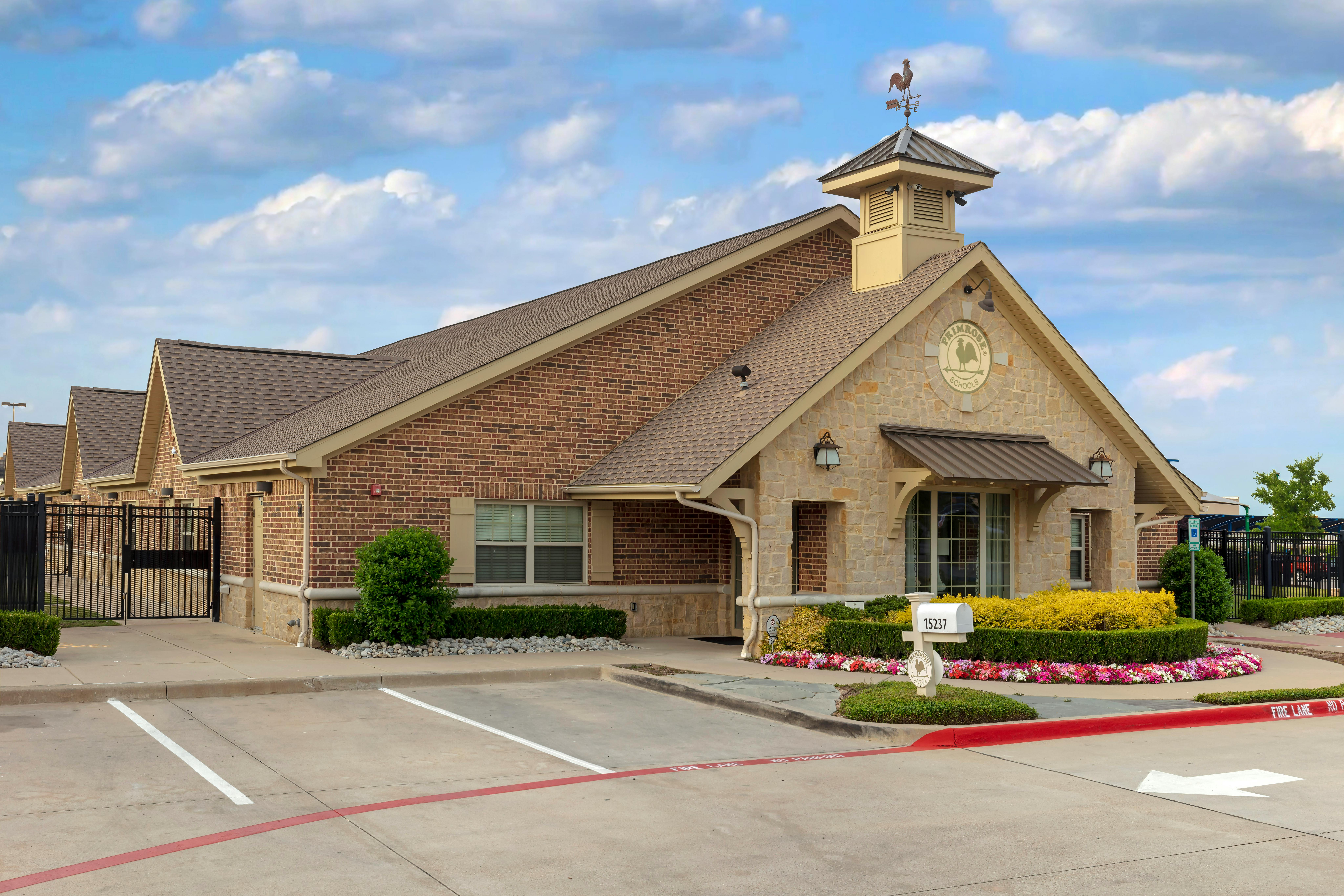Building entrance with a "Primrose Schools" sign, mailbox, and landscaping