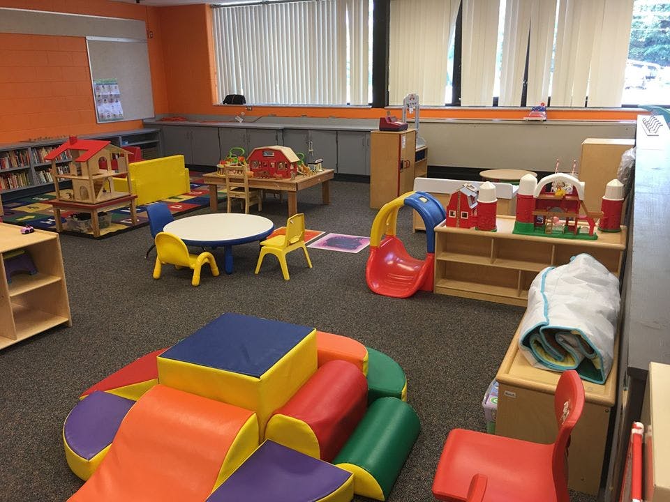Playroom with colorful soft play equipment, small tables, and toys