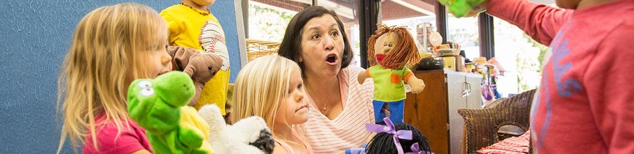 Adult and children playing with puppets