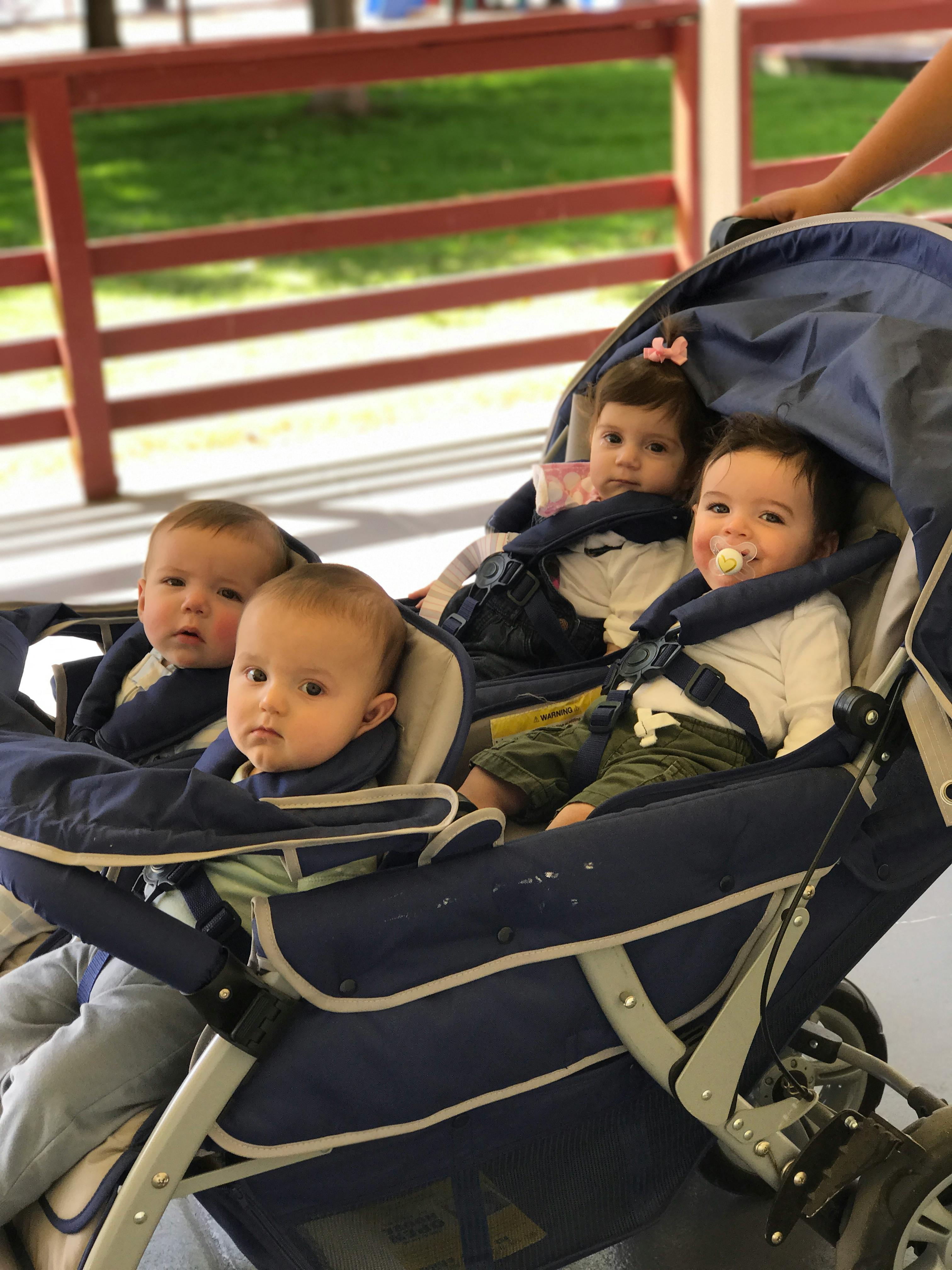 Three children in a multi-seat stroller