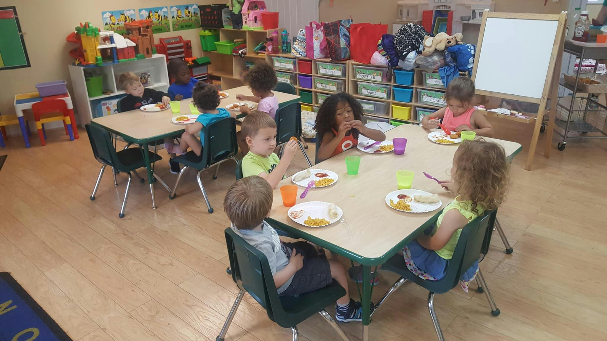 Children eating at tables in a classroom