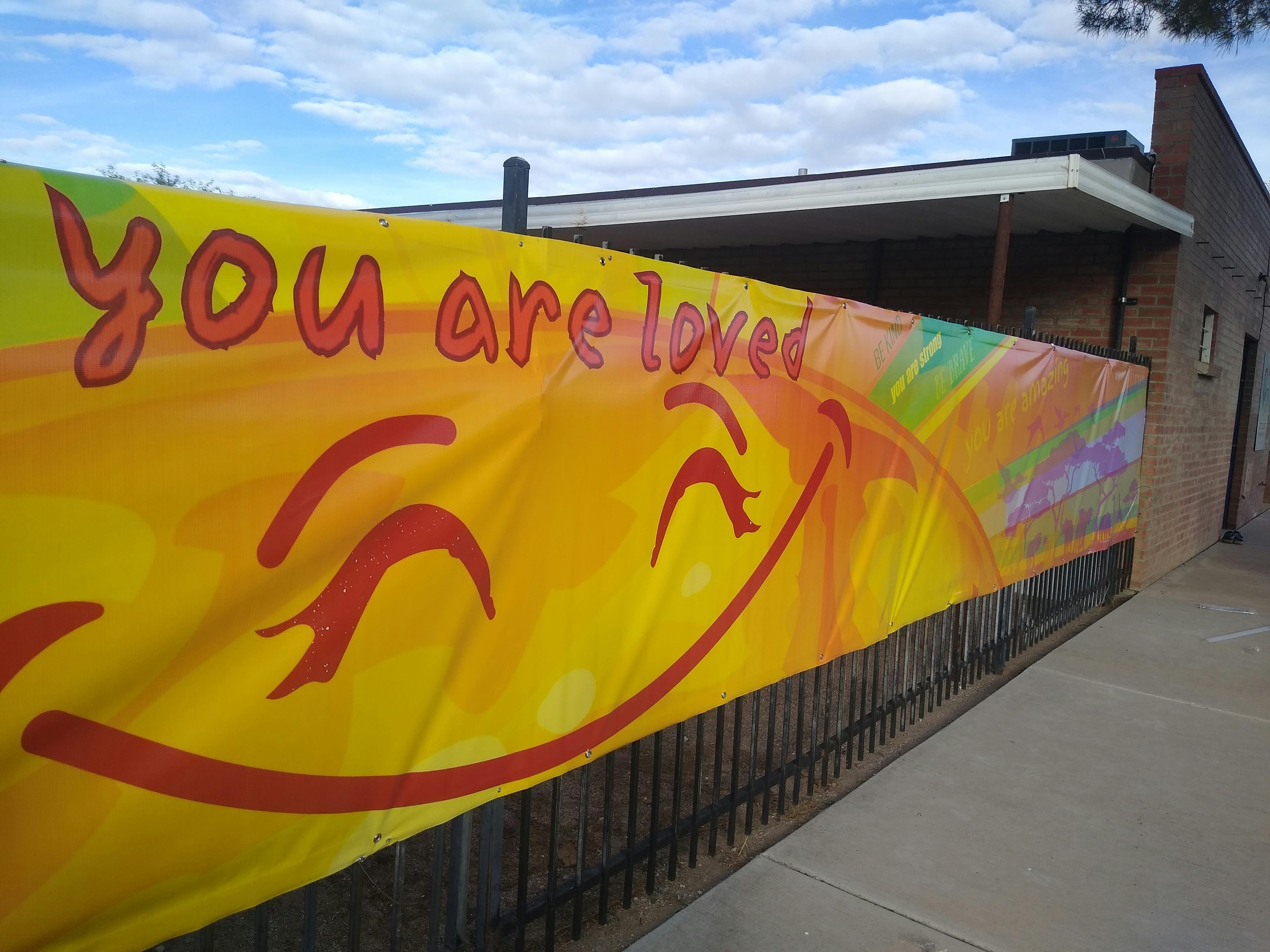 Yellow banner with "you are loved" and a smiling face