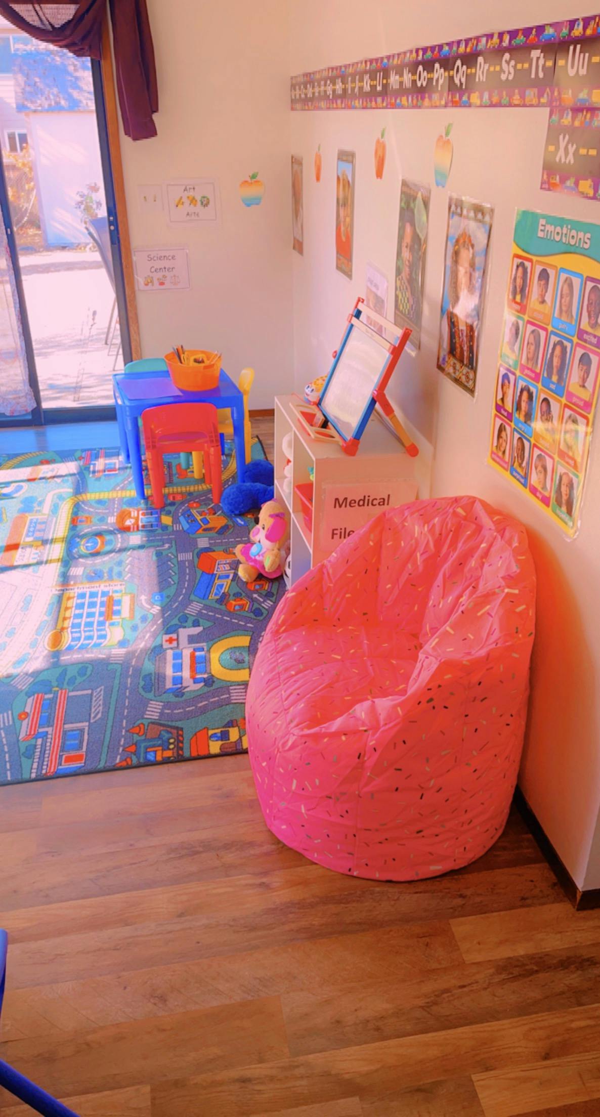 Playroom with a beanbag chair, small table, and alphabet chart on the wall