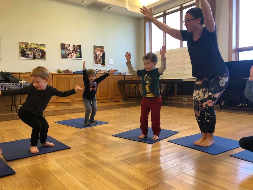 Adult and children doing yoga poses on mats