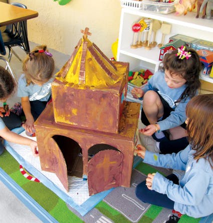 Children playing with a cardboard church model