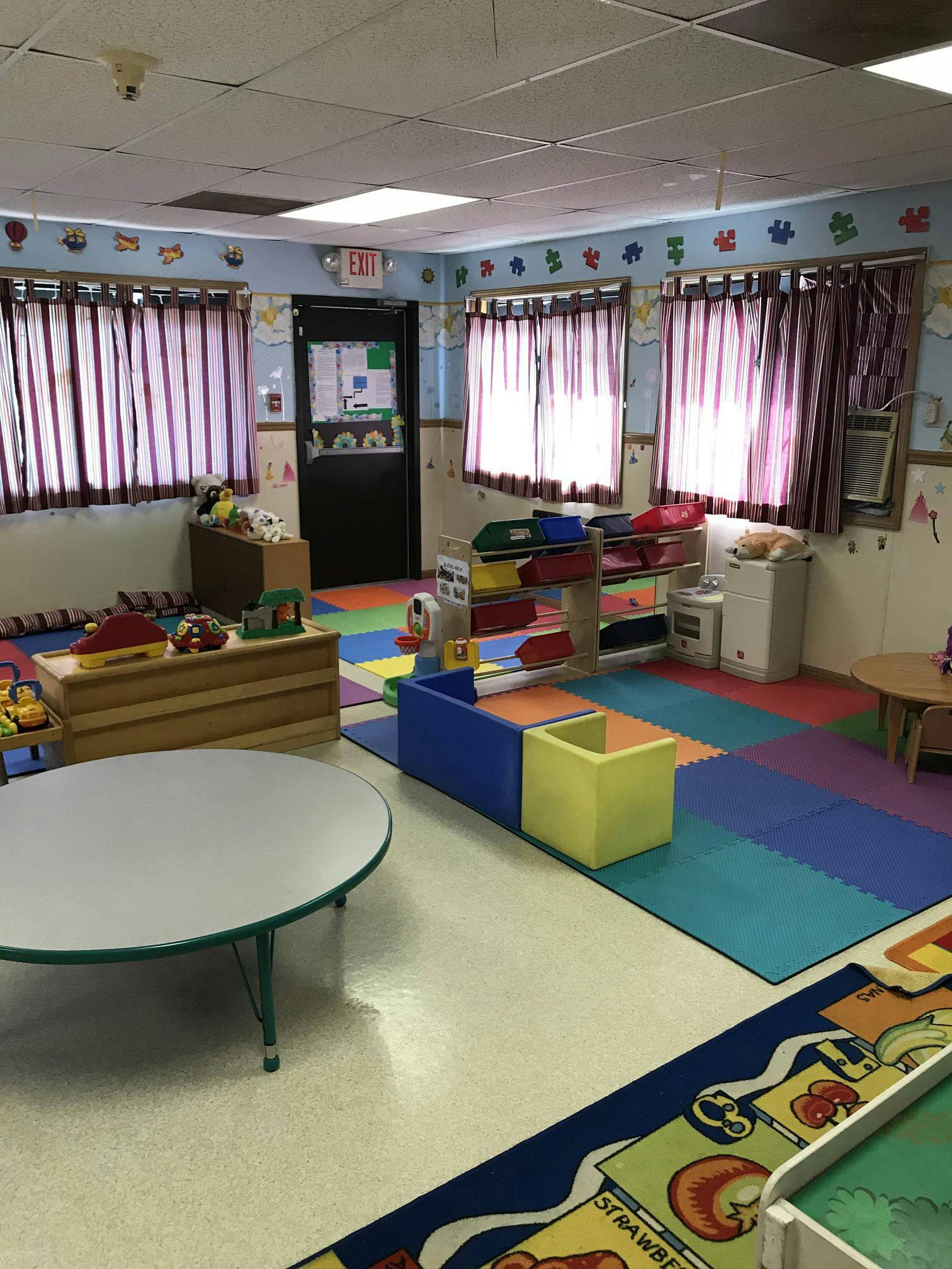 Empty classroom with colorful floor mats and small tables