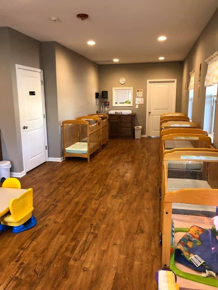 Room with multiple cribs and a changing table