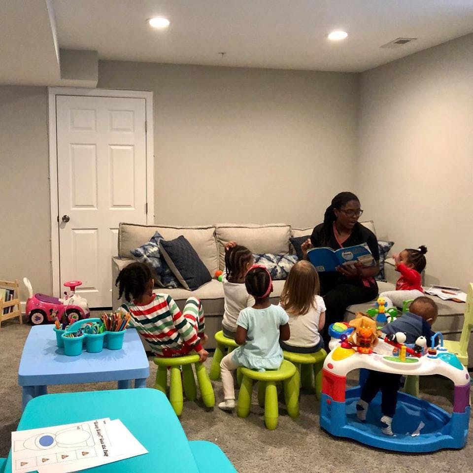 Person reading a book to a group of children