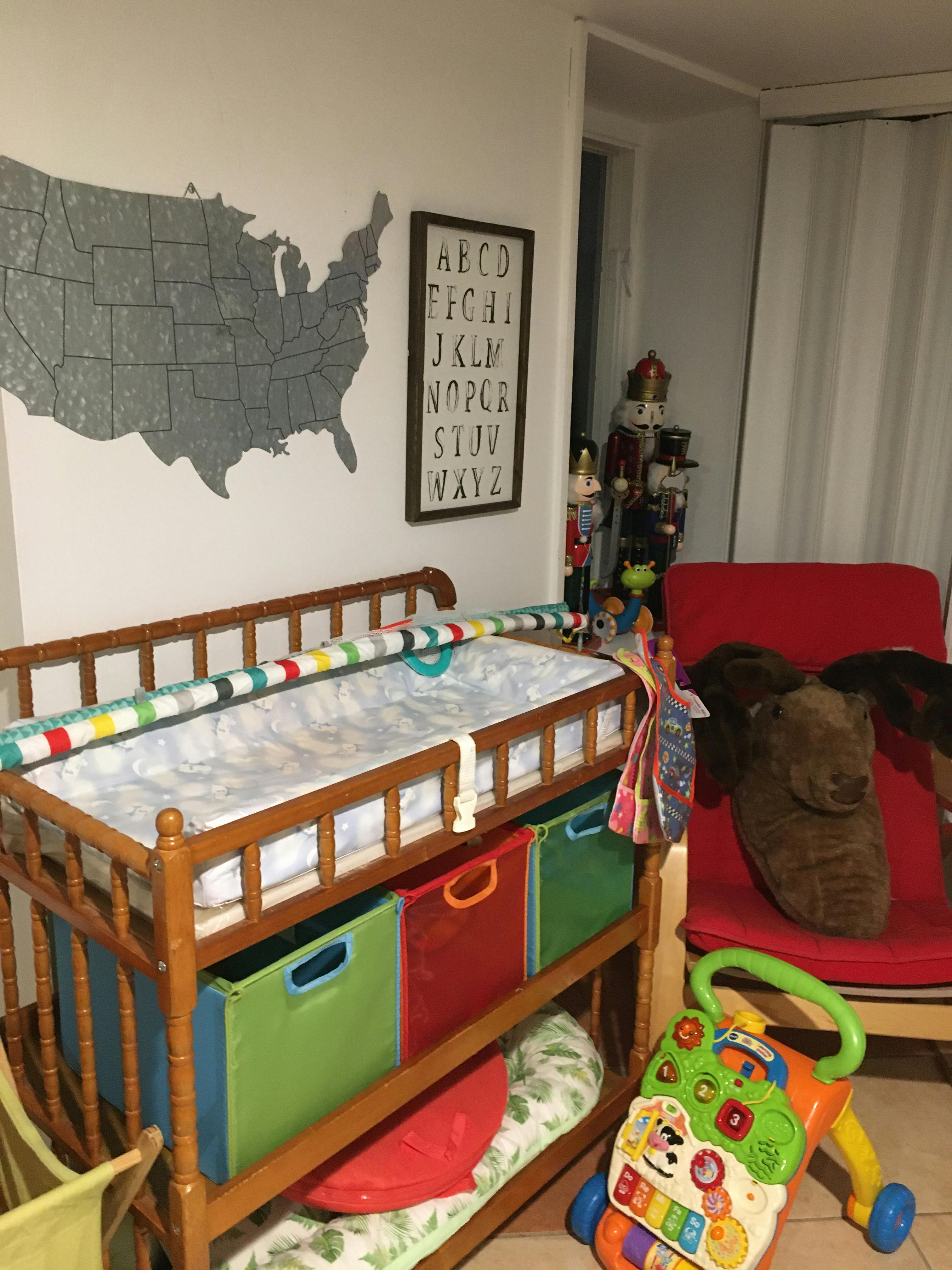 Changing table with colorful storage bins and a baby walker