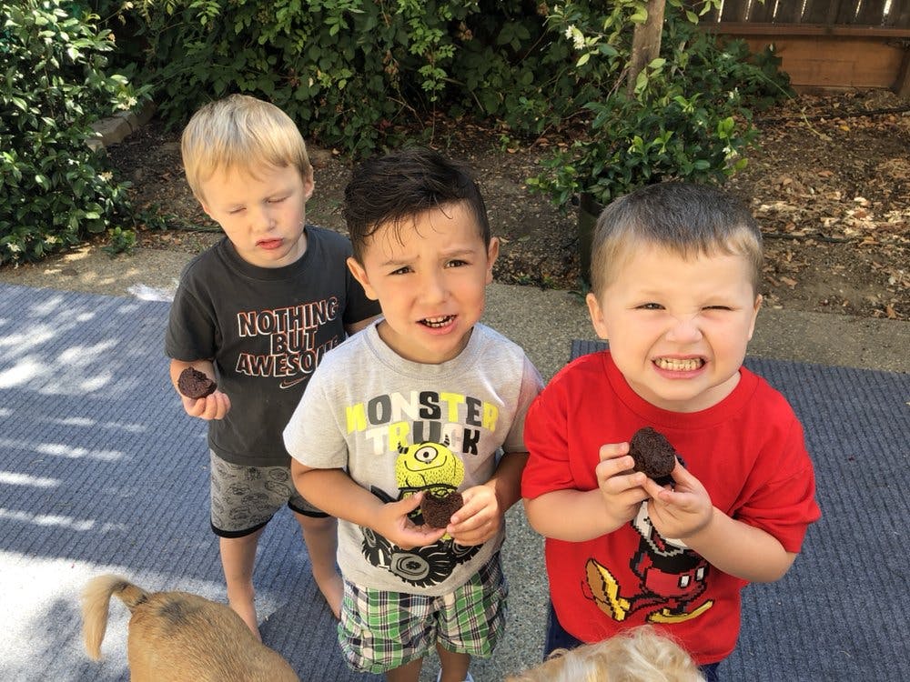 Three children holding small dark objects
