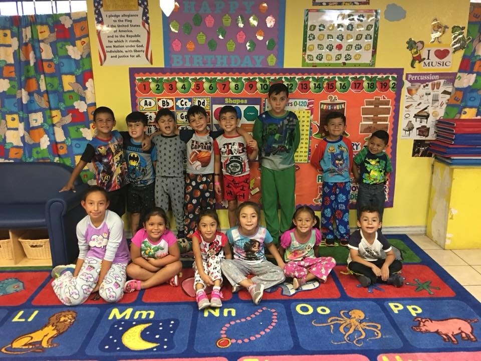 Group of children in pajamas posing in a classroom