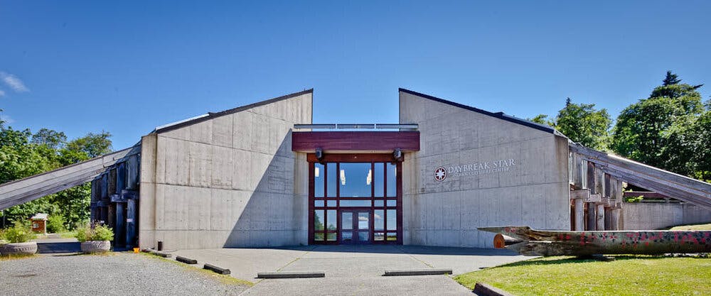 Modern building with a large glass entrance and angled concrete walls