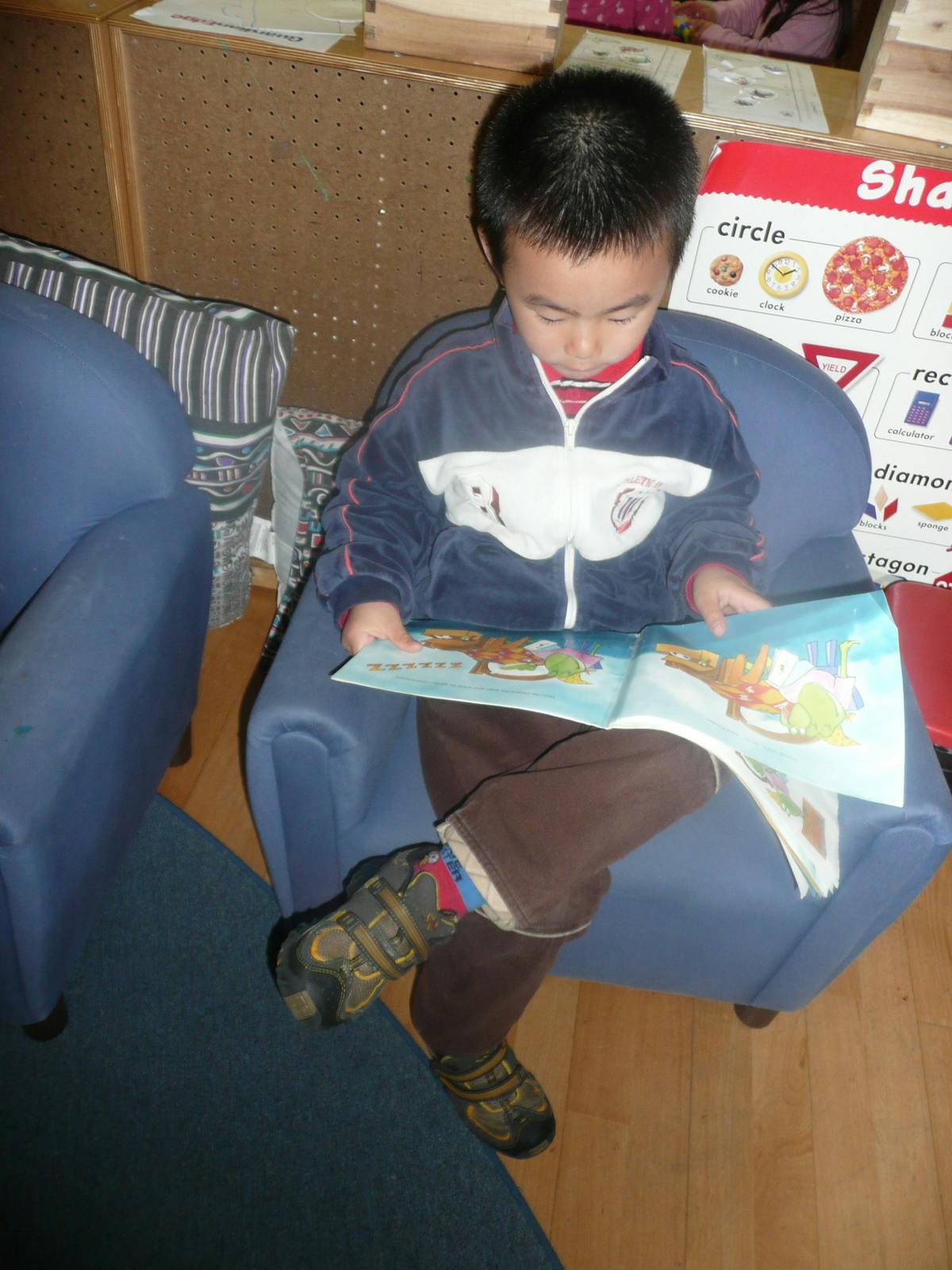 Child sitting in a chair reading a book