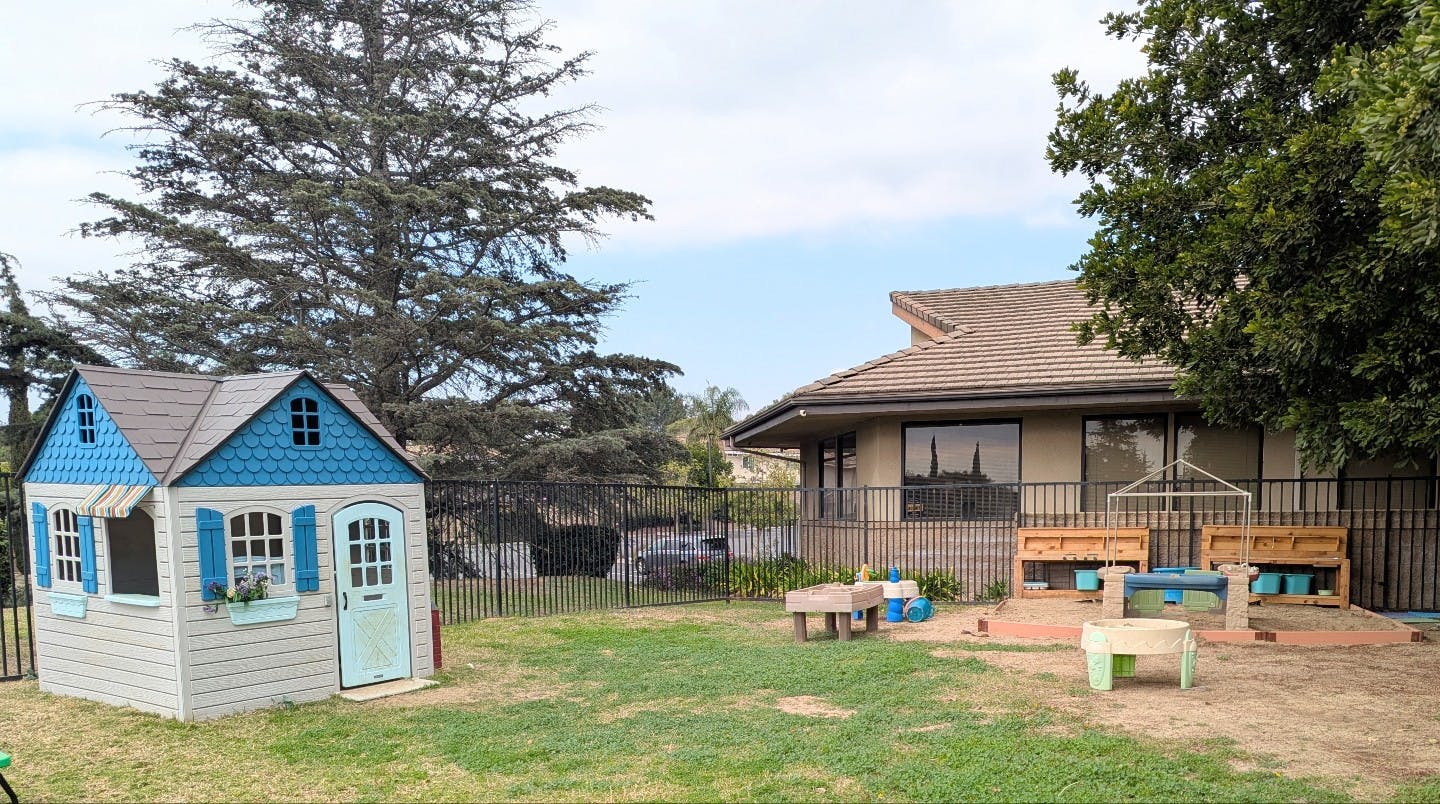 Playhouse and building in a grassy yard