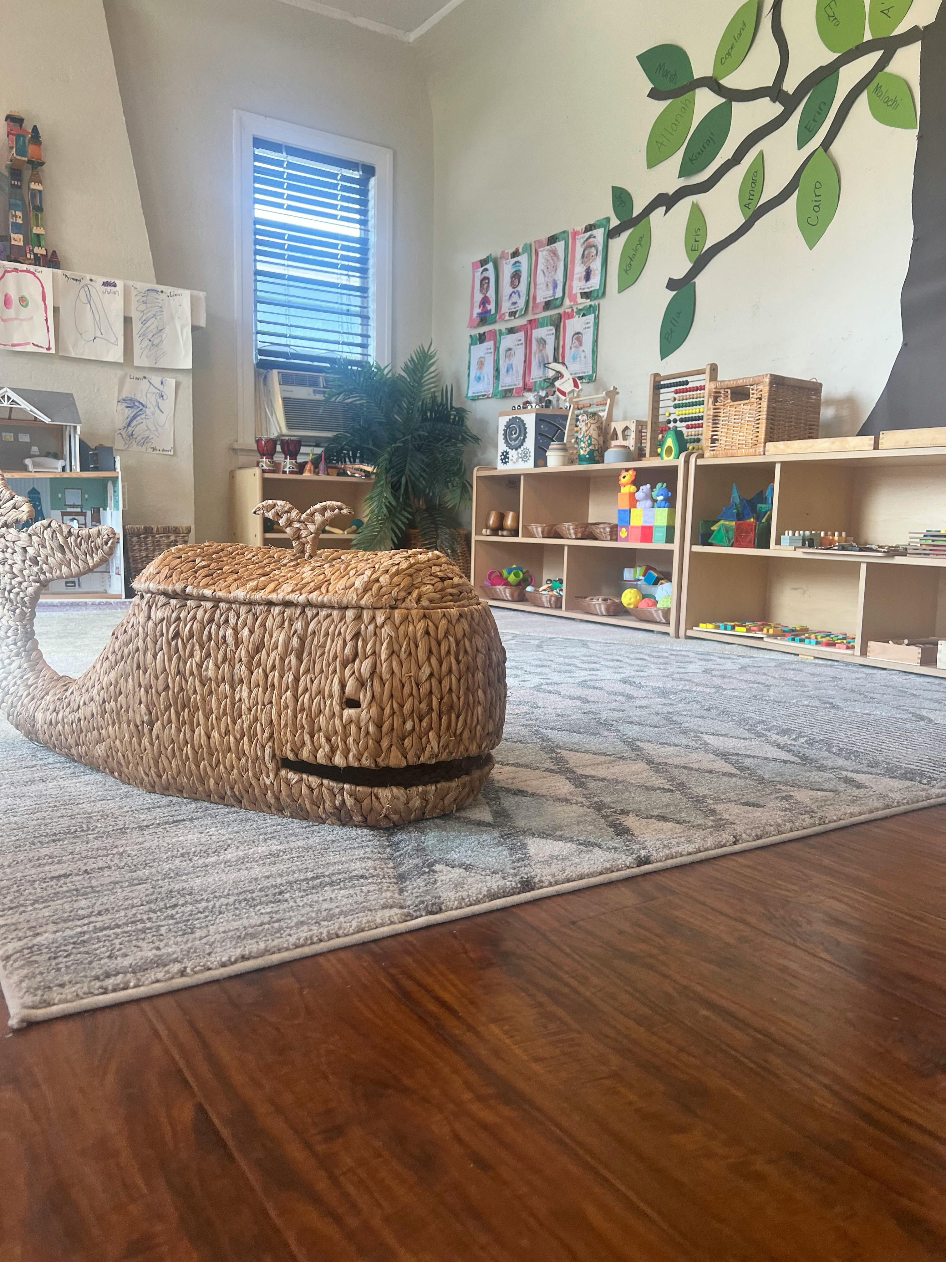 Woven whale-shaped storage bin on a rug in a classroom