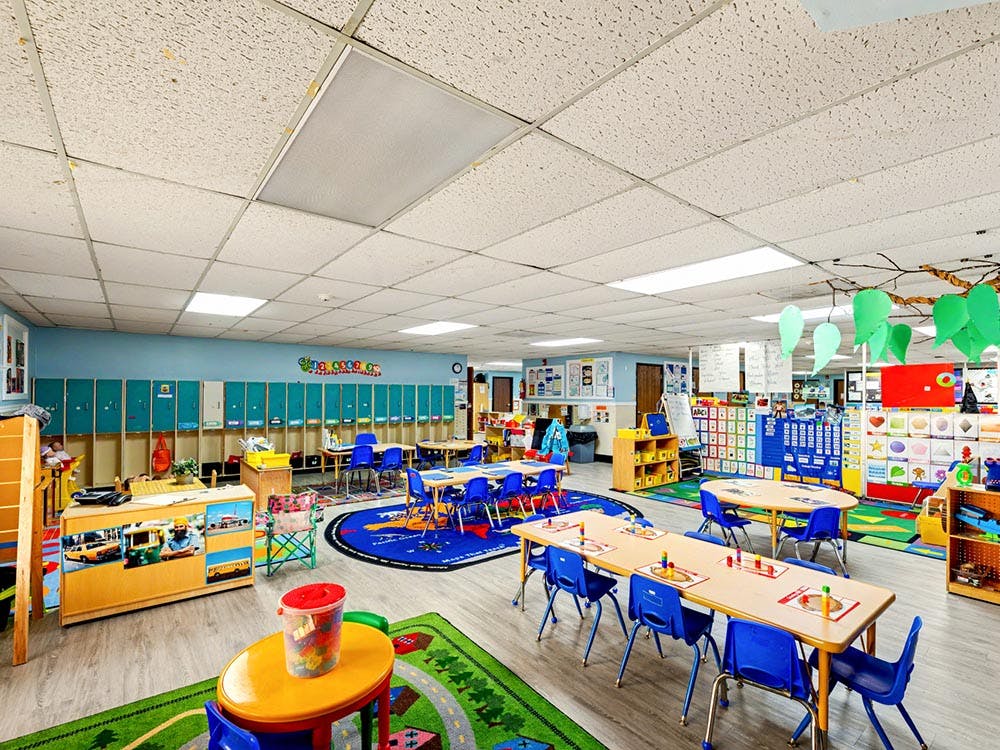 Empty colorful classroom with small tables and chairs