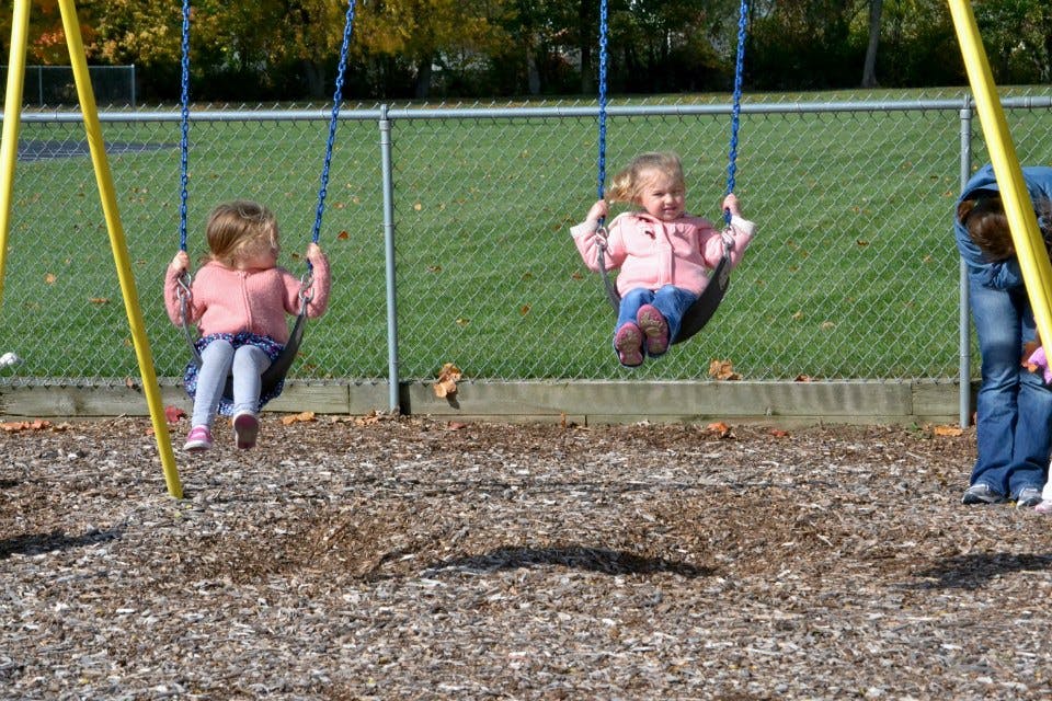 Two children on swings at a playground