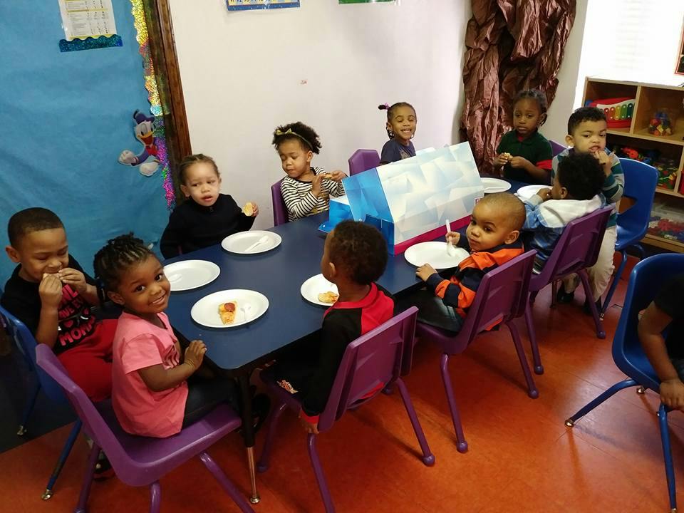 Children sitting at a table with plates