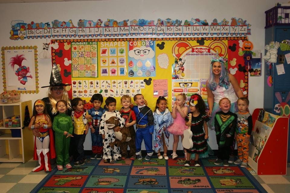 Children and adults in costumes in a classroom