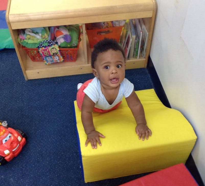 Child crawling on a yellow mat