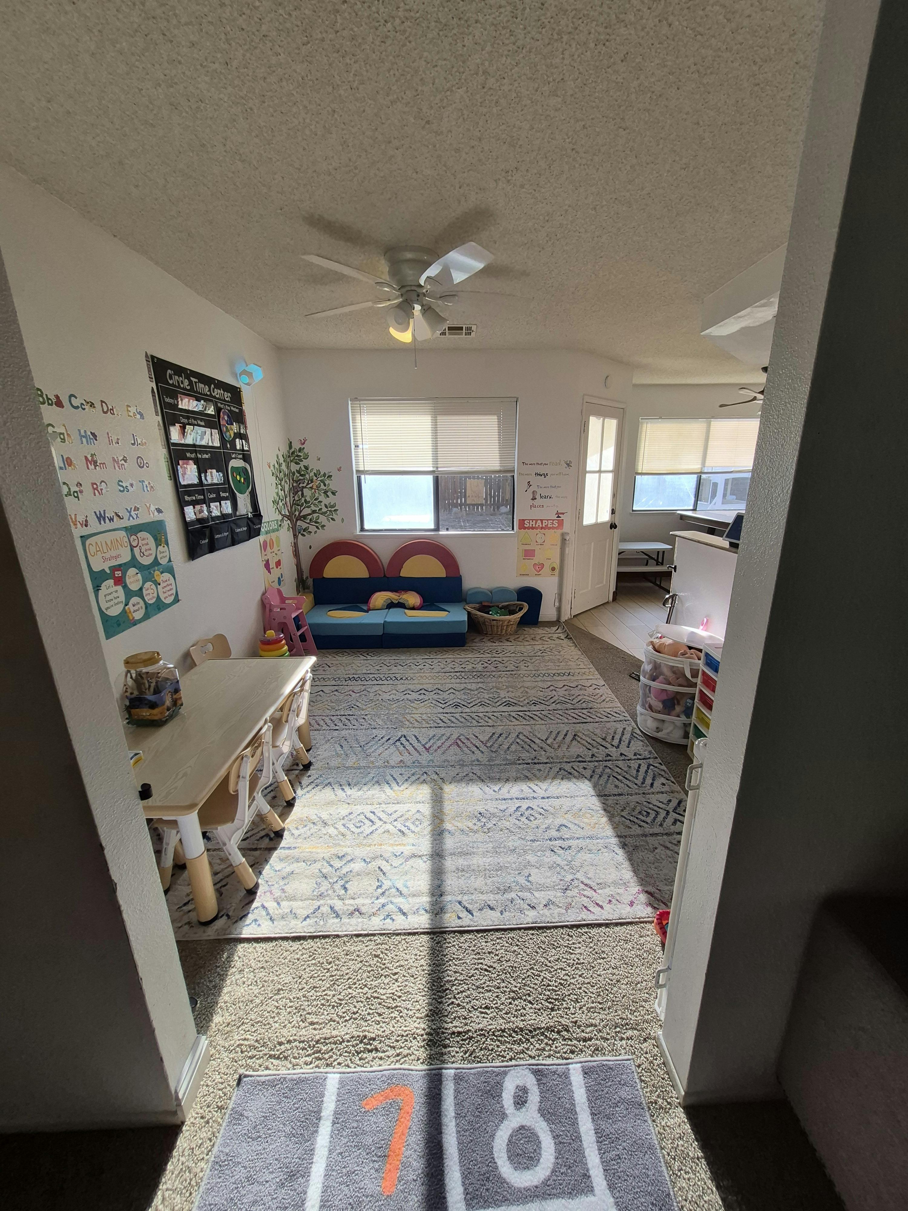 Classroom with children's table and chairs, teaching charts, and play seating