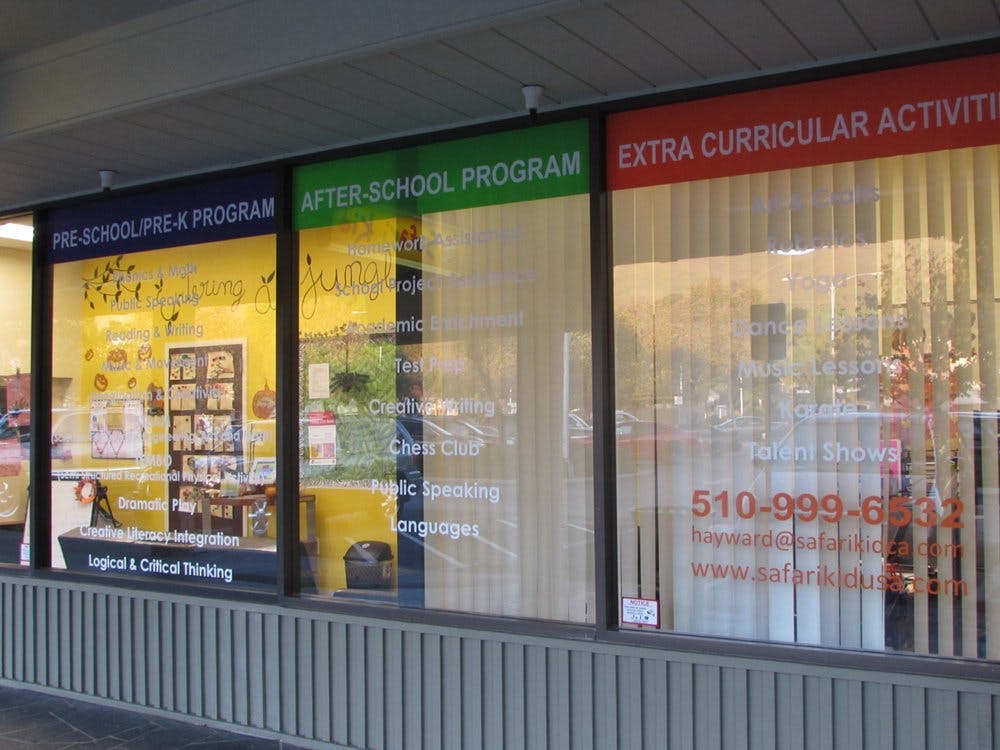 Storefront windows with signs for "Pre-School Pre-K Program" and "After-School Program"