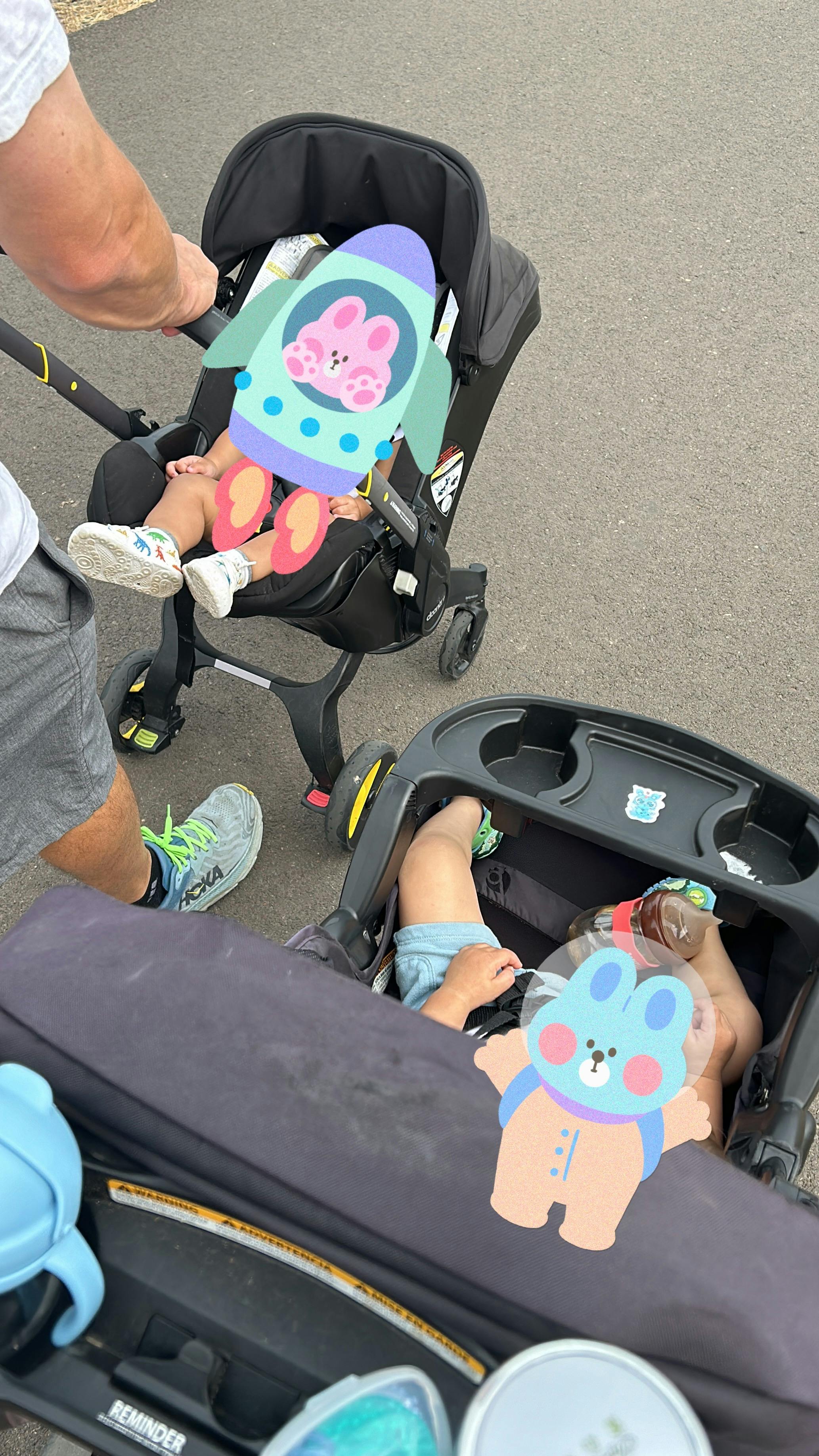 Person pushing two children in strollers outdoors