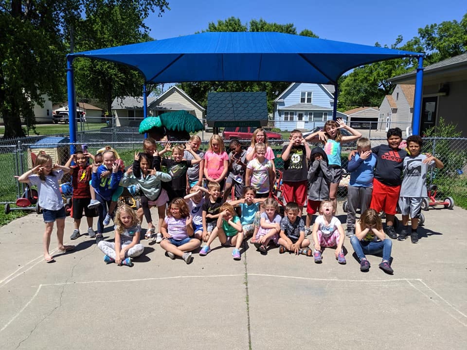 Group of children making funny faces under a blue canopy