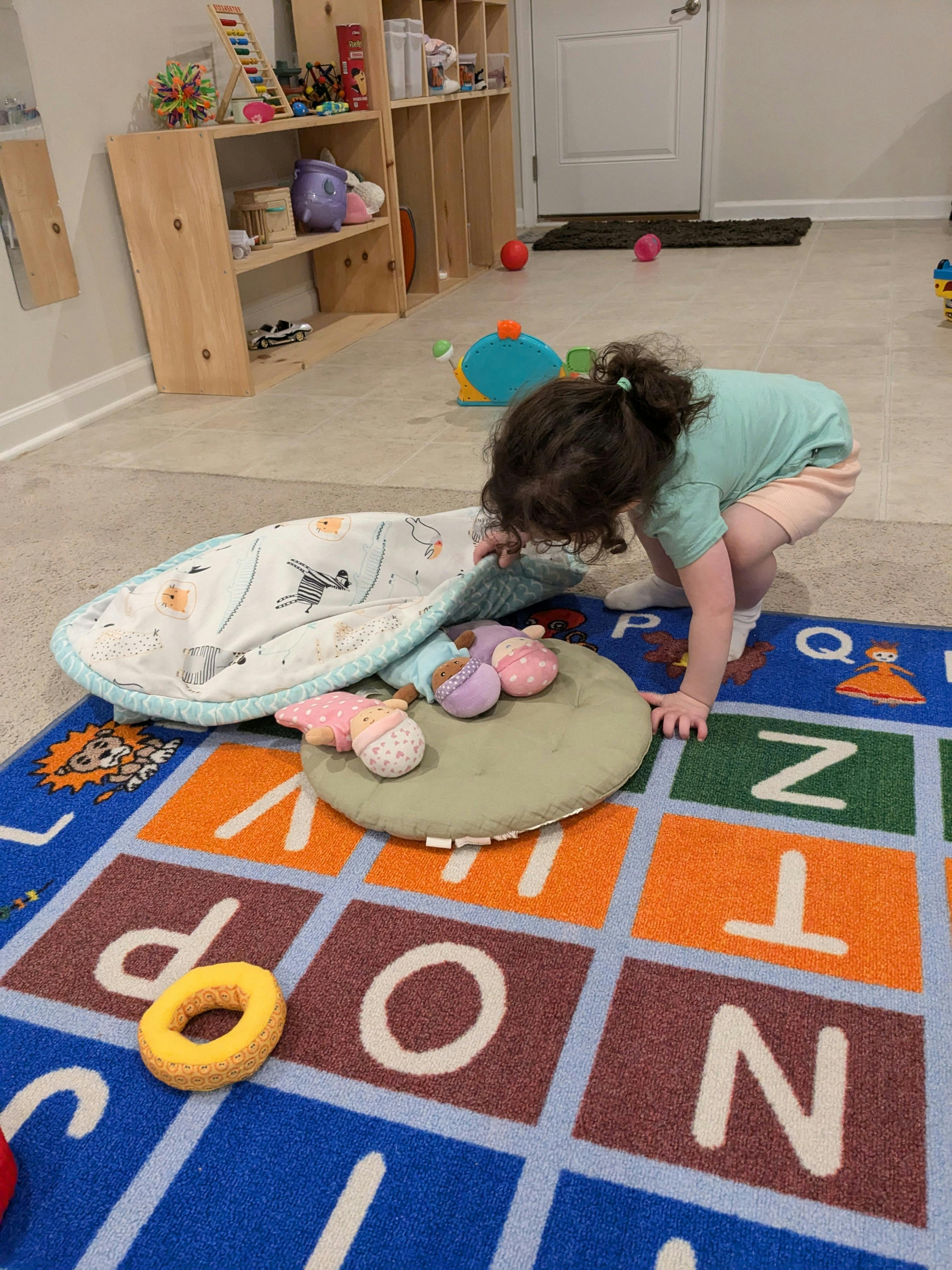 Child on hands and knees on an alphabet rug