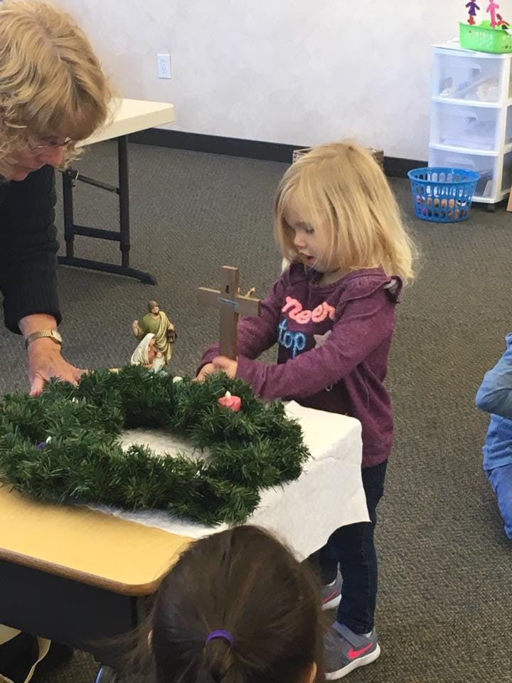Adult and child decorating a wreath