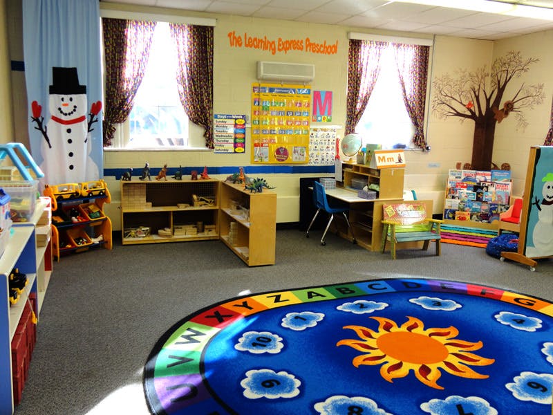 Classroom with a colorful rug, shelves, and a snowman decoration
